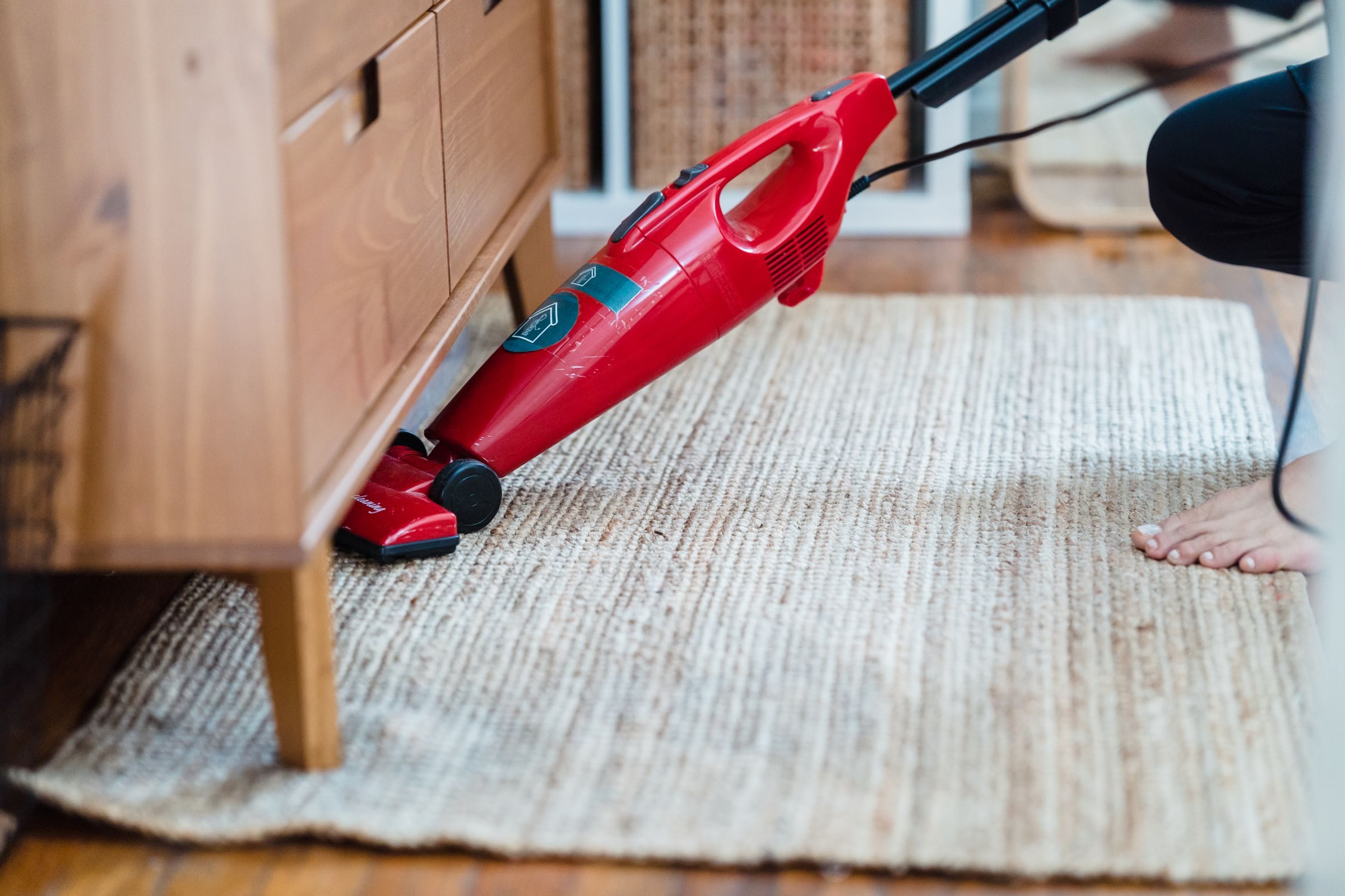 Aspirateur balai filaire simple passé sous un meuble